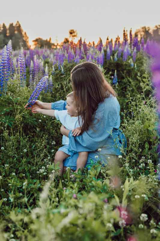 eltern-alleinerziehend Mutter sitzt mit Baby in Blumenwiese